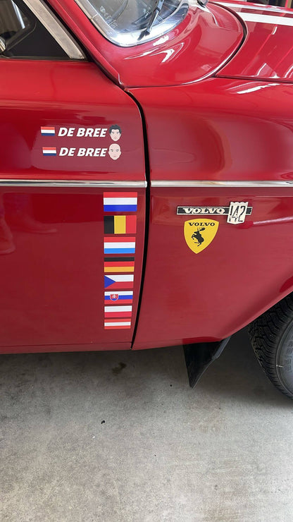 Gelamineerde Vlaggenstickers op een rode auto, ideaal voor persoonlijke stijl en decoratie.