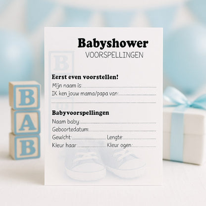 Blauwe babyshower invulkaart op feesttafel met houten BABY-blokken, cadeautje en blauwe ballonnen