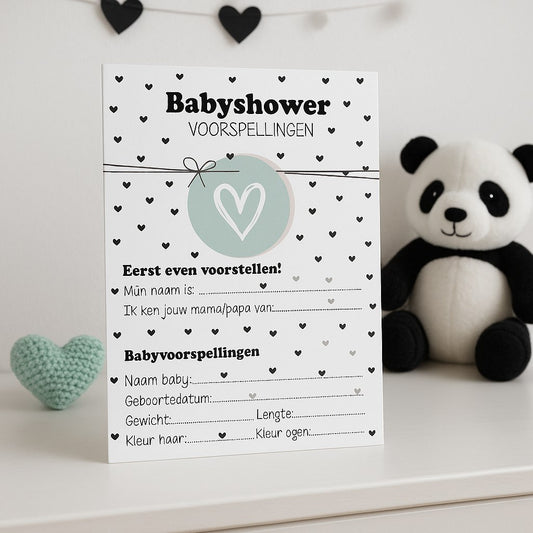 Zwart-wit babyshower invulkaart met hartjes op een witte dressoir met knuffelpanda en mint hartenkussen