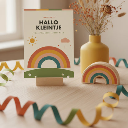 Retro babyshower invulkaart rechtop naast een houten regenboog en droogbloemen in een mosterdgele vaas