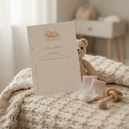 Babyshower namenspel-kaart tegen een knuffelbeer op een gebreide deken met babysokjes